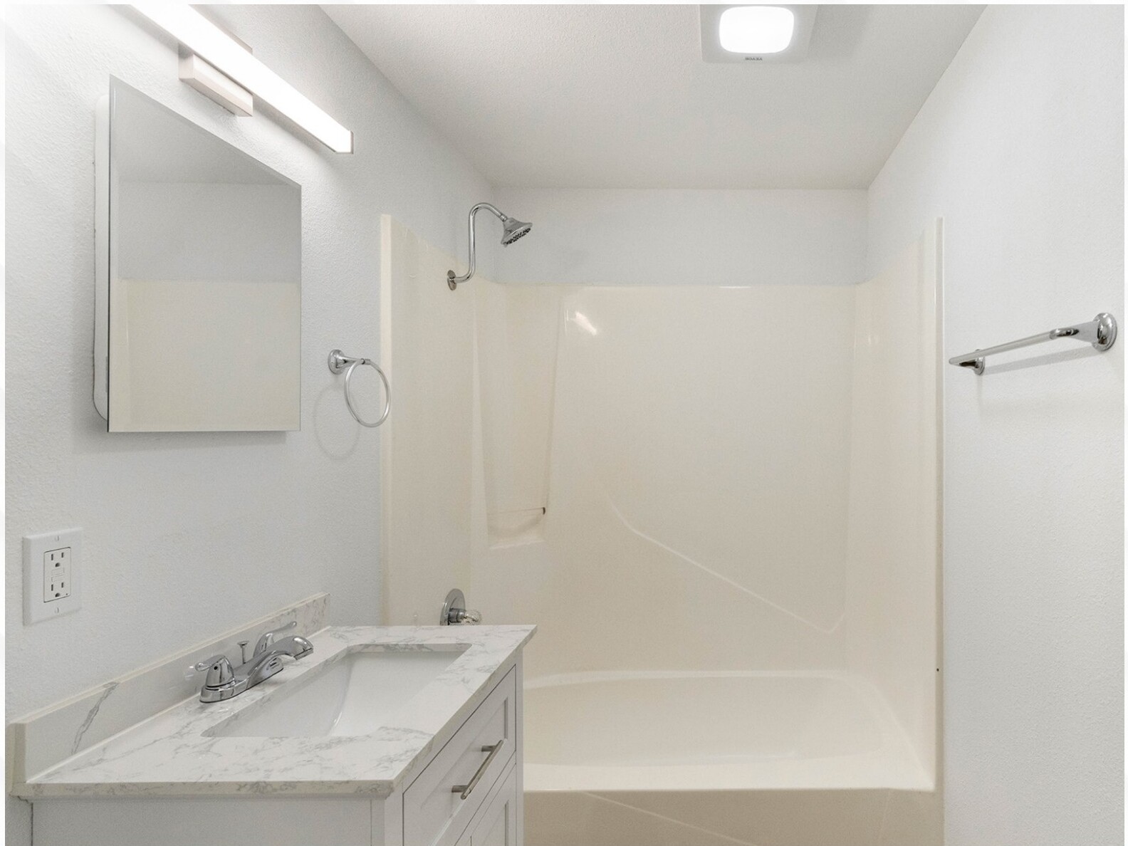 Bathroom with vanity and shower tub combo